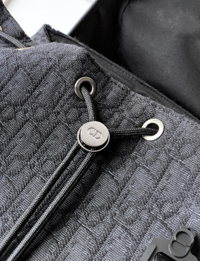 Borsa elegante in tessuto grigio con chiusura a drawstring e logo in metallo raffinato.