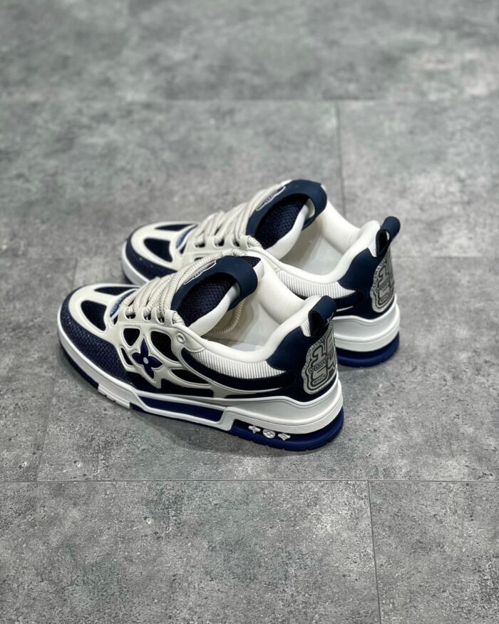 Sneakers bianche e navy moderne, stile sportivo e casual, dettagli eleganti e comodi fit.
