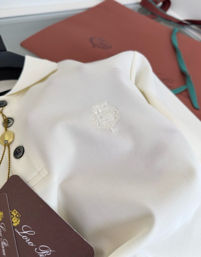 Maglietta polo bianca elegante con logo ricamato, stile classico e materiali di alta qualità.