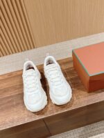 Sneaker bianche moderne su superficie in legno con confezione elegante, stile minimalista e trendy.