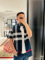 Selfie di giovane in negozio con camicia a quadri e stile urbano trendy.
