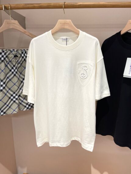 Outfit estivo casual con t-shirt bianca, pantaloncini a quadri e maglia nera minimalista.