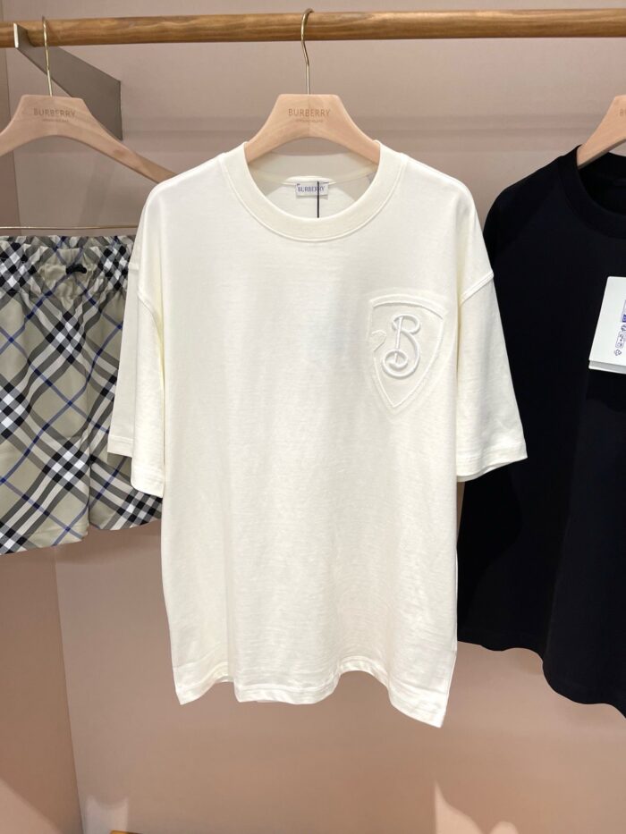 Outfit estivo casual con t-shirt bianca, pantaloncini a quadri e maglia nera minimalista.