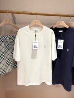 Abbigliamento estivo casual: t-shirt beige e navy con shorts a quadri chiari.
