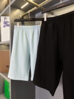 Pantaloncini estivi blu e neri in esposizione elegante con marca di lusso.