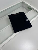 Maglia nera con piccole strisce sulla manica, elegante e semplice, perfetta per uno stile casual.