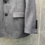 Blazer grigio sartoriale con bottoni neri, stile elegante e dettagli di alta qualità.