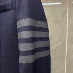 Manica blazer navy con dettagli a fasce checked, stile elegante e moderno.
