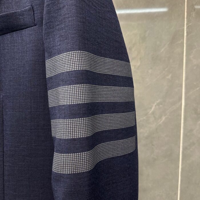 Manica blazer navy con dettagli a fasce checked, stile elegante e moderno.