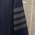 Blazer navy elegante con dettagli moderni a strisce sul braccio, stile classico e sofisticato.