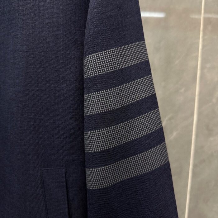 Blazer navy elegante con dettagli moderni a strisce sul braccio, stile classico e sofisticato.