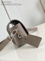 Borsa piccola in pelle taupe con tracolla regolabile e chiusura decorativa in metallo.