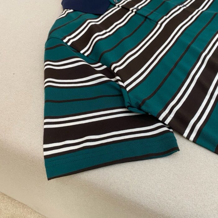 Maglietta polo a righe teal con colletto blu navy, stile casual estivo e tessuto leggero.