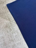 Contrasto tra tessuto beige morbido e similpelle blu navy elegante in interno raffinato.