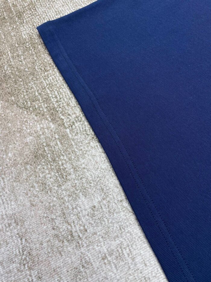 Contrasto tra tessuto beige morbido e similpelle blu navy elegante in interno raffinato.