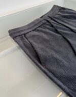 Pantaloni in velluto di corduroy grigio scuro, casual e eleganti, con tasche e vita elasticizzata.
