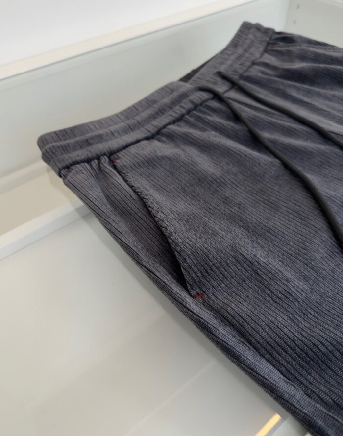 Pantaloni in velluto di corduroy grigio scuro, casual e eleganti, con tasche e vita elasticizzata.