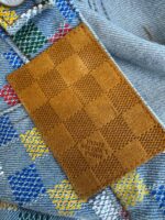 Toppa in pelle su jeans colorati con motivo checkered vivace e dettagli di alta qualità