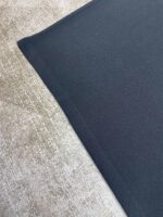 Contrasto tra tessuto nero lucido e morbido beige con diverse texture e colore.