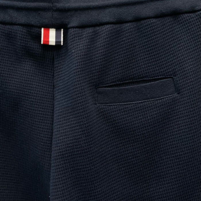 Pantaloni navy con tasche moderne, etichetta a strisce, tessuto resistente e stile casual raffinato.