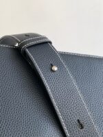 Cinghia in pelle grigia con cuciture bianche e hardware metallico di alta qualità.