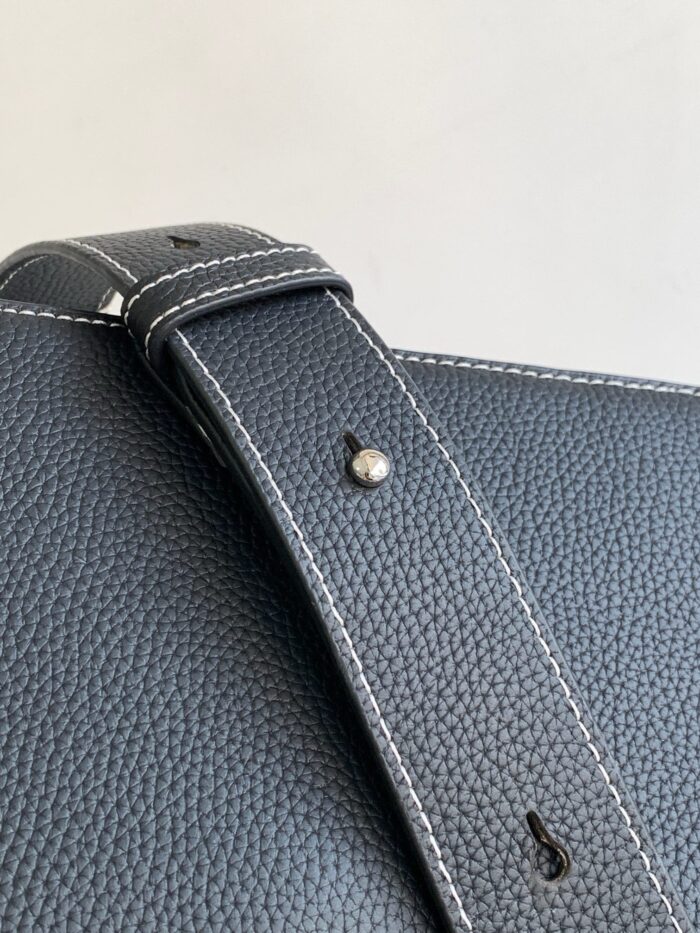 Cinghia in pelle grigia con cuciture bianche e hardware metallico di alta qualità.