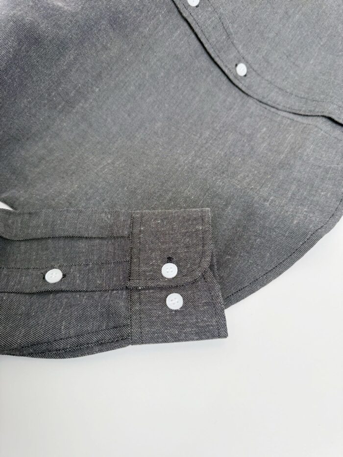 Camicia grigia casual con colletto tradizionale e polsini doppi, elegante e versatile.