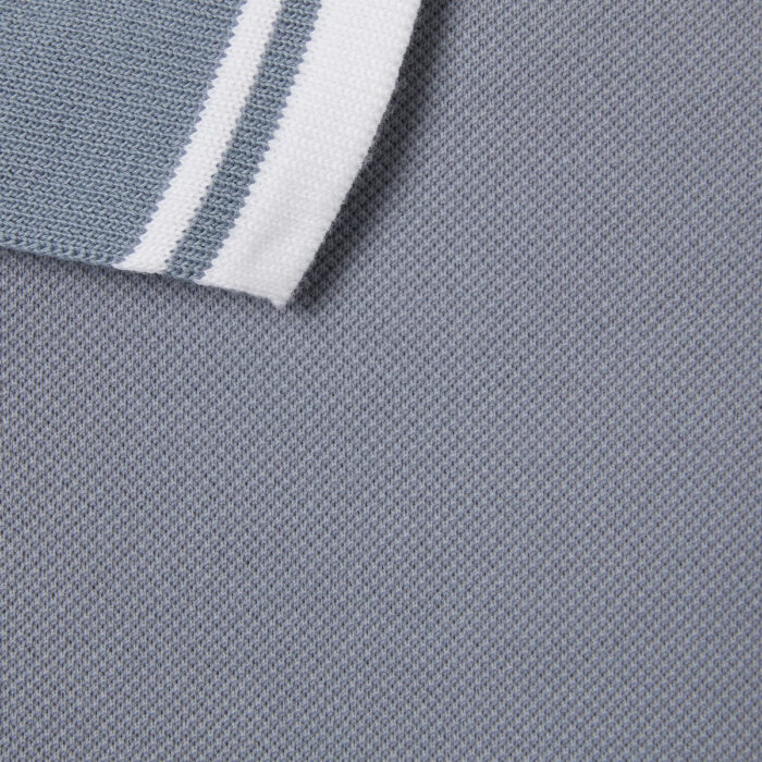 Polo grigia con colletto a righe bianche, tessuto morbido e stile moderno ed elegante.