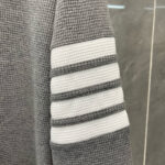 Manica grigia con righe bianche, tessuto a nido dape, stile casual e comfort.