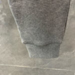 Risvolto in tessuto grigio elasticizzato, morbido e comodo per pantaloni jogger sportivi.