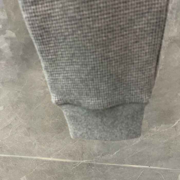 Risvolto in tessuto grigio elasticizzato, morbido e comodo per pantaloni jogger sportivi.