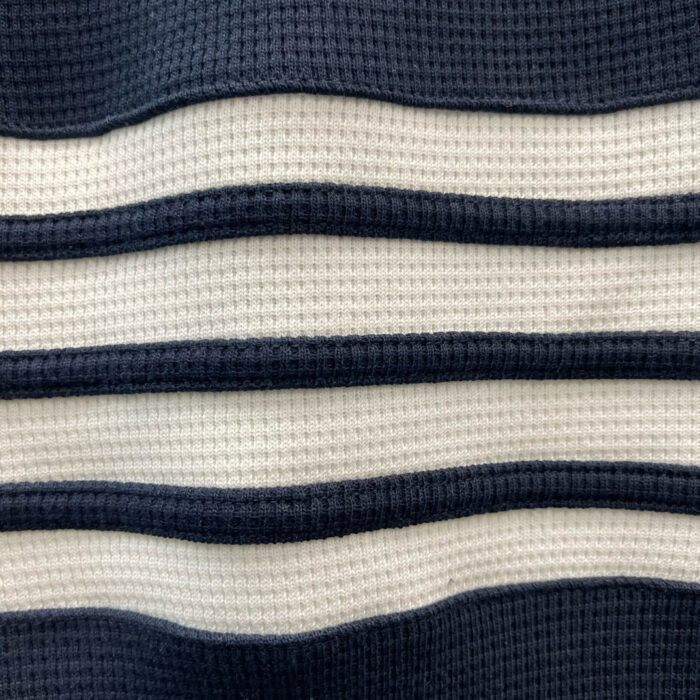 Tessuto a righe navy e cremoso, morbido, elasticizzato e ideale per abbigliamento e decorazioni.