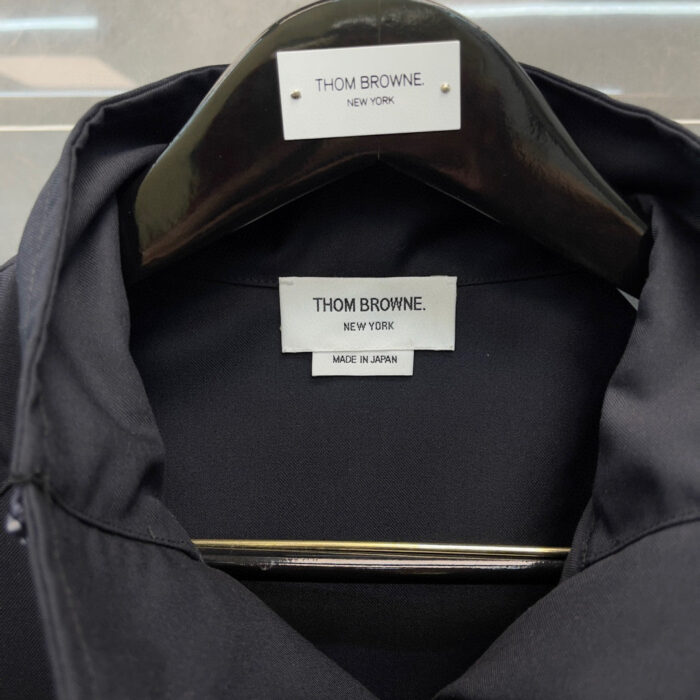Etichetta di Thom Browne Made in Japan su abbigliamento di lusso, dettagli di alta qualità.