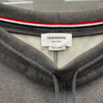 Colletto sweatshirt Thom Browne, cotone grigio, dettaglio righe rosso-bianco-blu, Made in Japan.