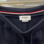 Elastico in vita Thom Browne con etichetta e dettaglio a righe rosse e bianche.