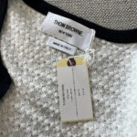 Etichetta e dettaglio del capo Thom Browne, made in Italia, con trame e linee eleganti.