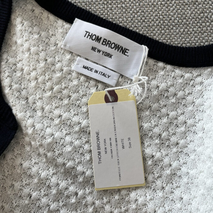 Etichetta e dettaglio del capo Thom Browne, made in Italia, con trame e linee eleganti.