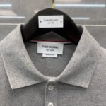 Maglietta polo grigia Thom Browne, Made in Italy, eleganza minimalista e qualità superiore.