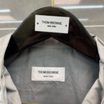 Etichetta di lusso Thom Browne Milano Moda Uomo, dettagli branding e tessuto elegante.