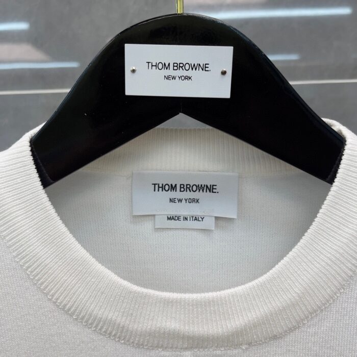 Camicia di lusso Thom Browne Made in Italy, elegante e minimalista, su appendiabiti.