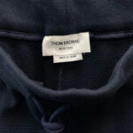 Etichetta Thom Browne Made in Japan su maglione navy, moda di lusso e qualità italiana.
