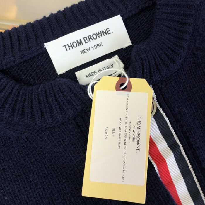 Maglione Thom Browne blu navy con dettagli di alta qualità, etichetta Made in Italy e dettaglio a strisce.