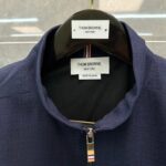 Giacca Thom Browne navy con zip, colletto a punta e dettagli colorati, Made in Japan.