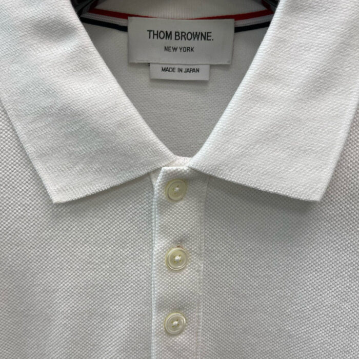 Maglietta polo bianca Thom Browne in tessuto testurizzato con dettagli di alta qualità.