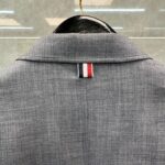 Elegante giacca sartoriale con dettaglio della bandiera tricolore rosso, bianco e blu.
