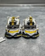 Sneakers moderne bianche con suola spessa, dettagli gialli e design streetwear di tendenza.