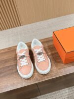 Sneakers pesca trendy con scatola arancione, stile moderno e design elegante in ambiente sofisticato.