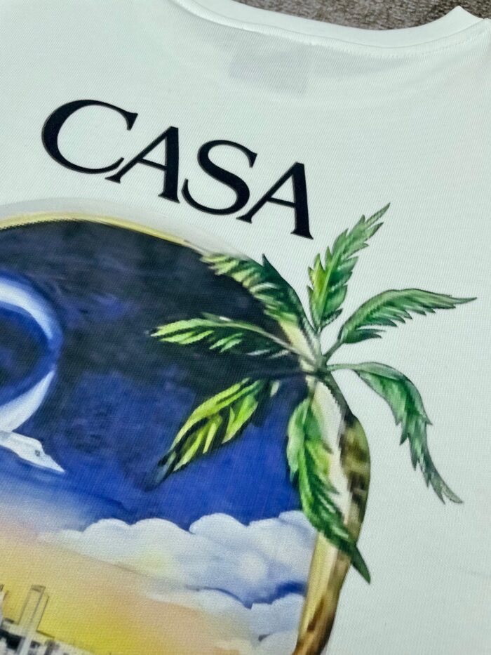 T-shirt tropicale con scritta CASA e palma su sfondo crepuscolare, stile relax e spiaggia.