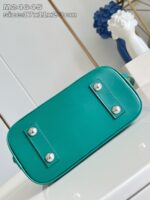 Borsa moderna in pelle turchese con bottoni argentati, stile minimalista e accessorio elegante.