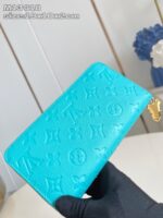 Portafoglio in pelle turchese con dettagli in oro e monogrammi di lusso.
